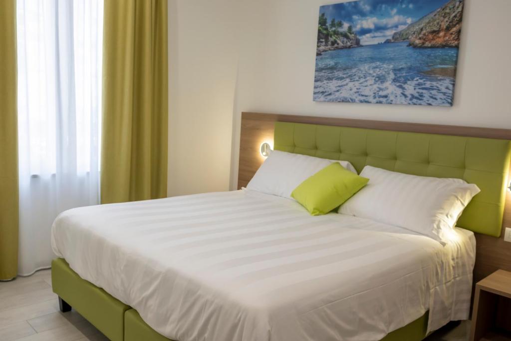 a bedroom with a large bed with a green headboard at Casa Marino in Sorrento