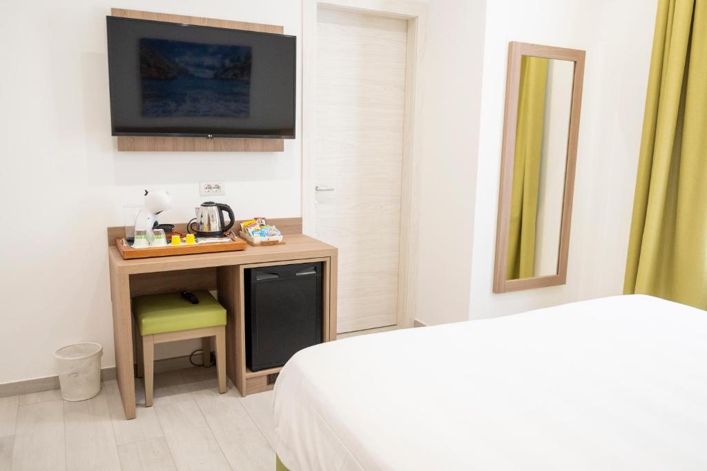 a bedroom with a bed and a desk with a television at Casa Marino in Sorrento