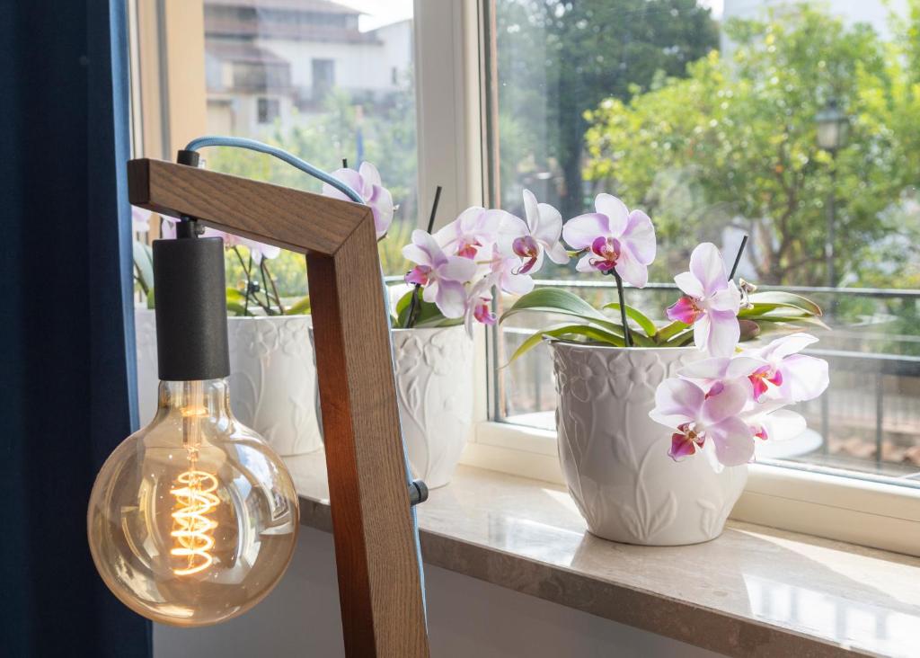 a window sill with three white vases with flowers on it at Casa Marino in Sorrento