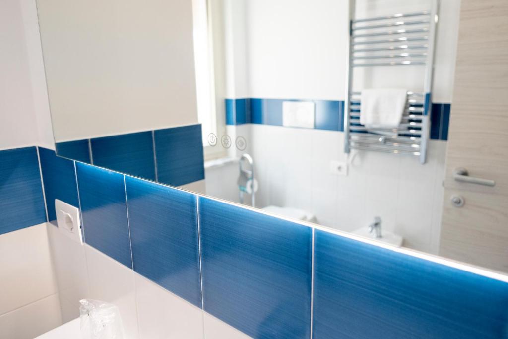 a bathroom with blue tiled walls and a mirror at Casa Marino in Sorrento