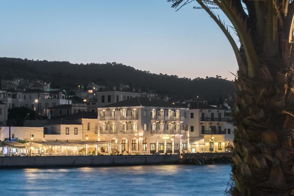 a group of white buildings next to a body of water at Klimis Hotel in Spetses