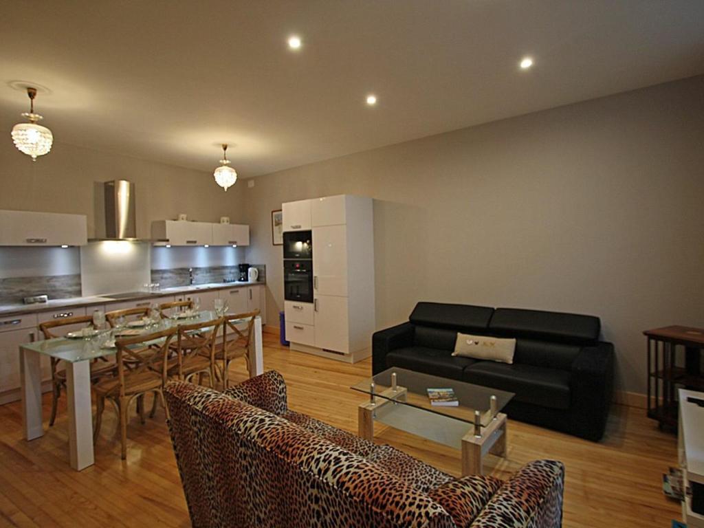 a living room with a black couch and a kitchen at Gîte Épinal, 4 pièces, 6 personnes - FR-1-589-82 in Épinal