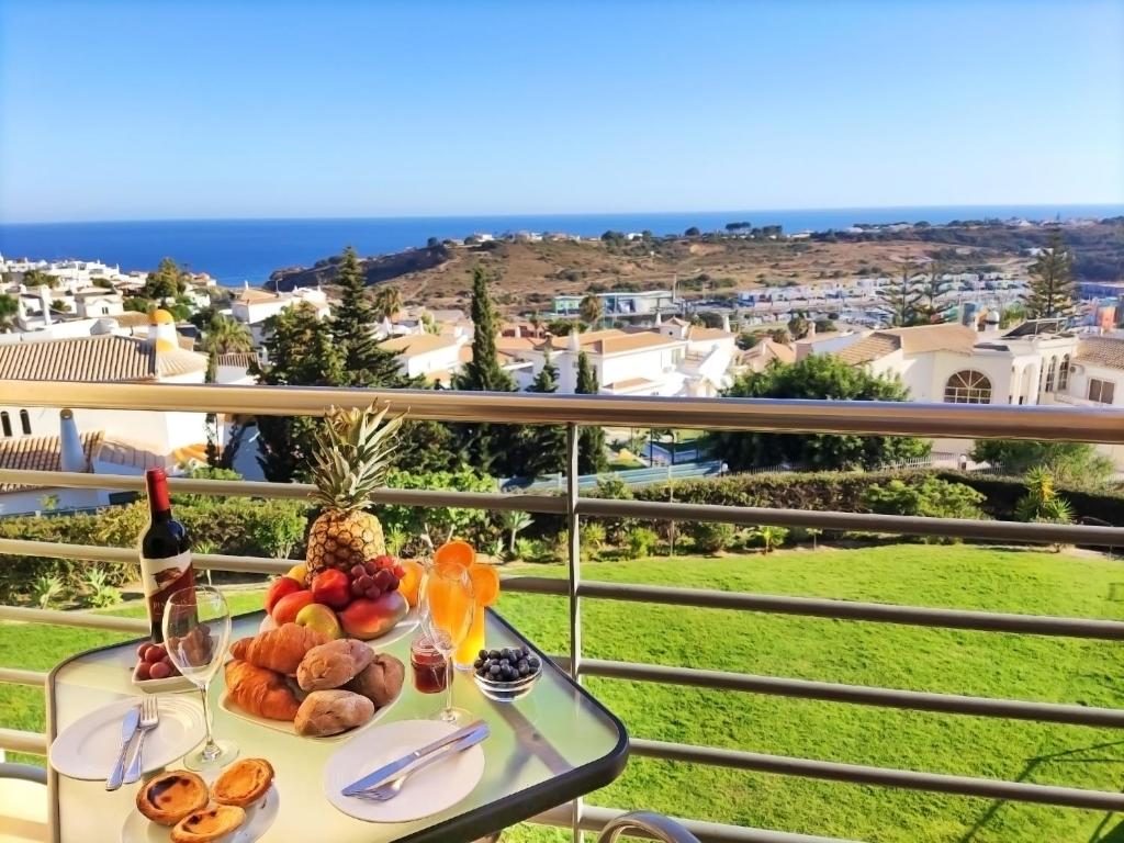 einen Tisch mit Obst und eine Flasche Wein auf dem Balkon in der Unterkunft Luxury Apartment Ocean View by Be Cherish in Albufeira