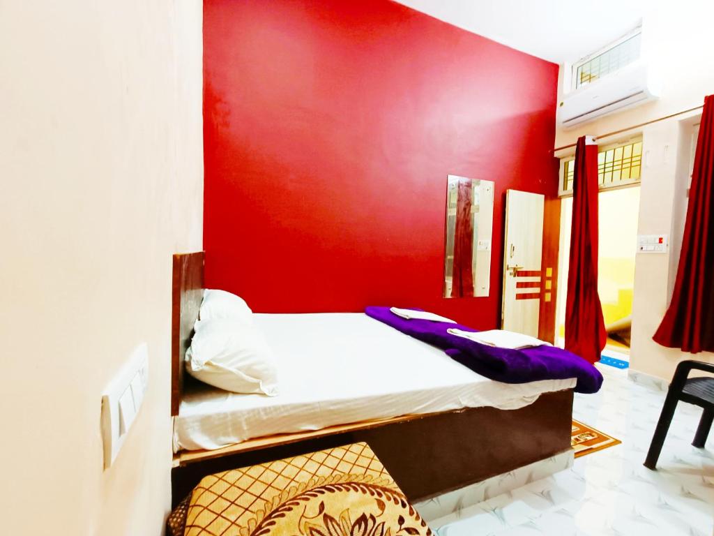 - une chambre avec un mur rouge et 2 lits superposés dans l'établissement hari Darshan, à Orchha