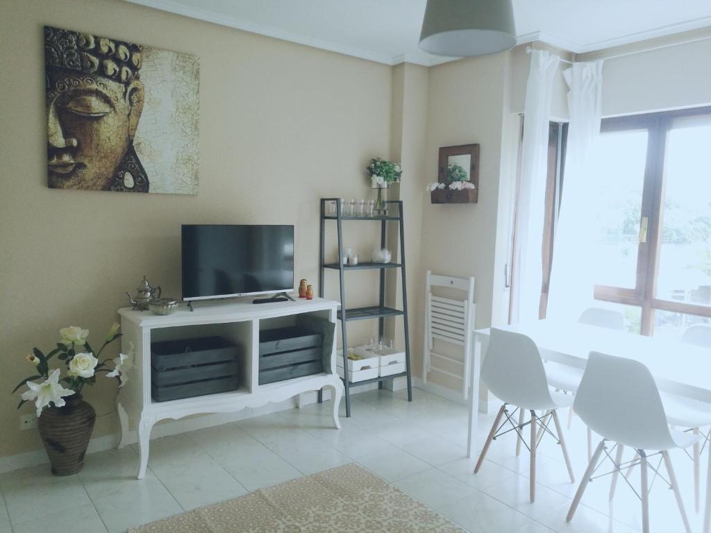 una sala de estar con TV en un armario blanco en Apartamento a cuatro minutos caminando de la playa, en Noja
