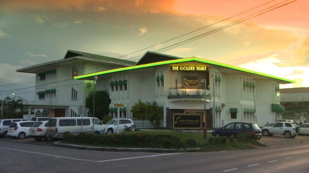 a car parked in front of a large building at The Golden Truly Hotel & Casino in Paramaribo