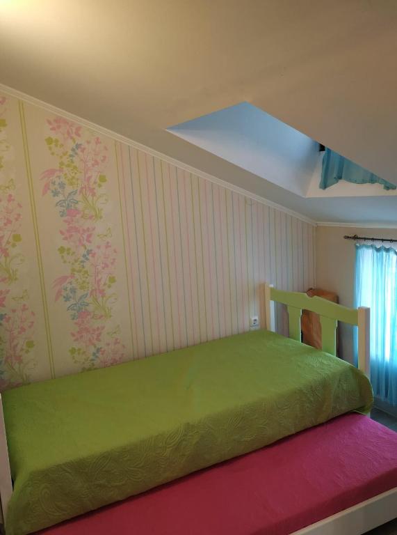 sypialnia z zielonym łóżkiem w pokoju w obiekcie Palm Garden Villa w mieście Orfánion