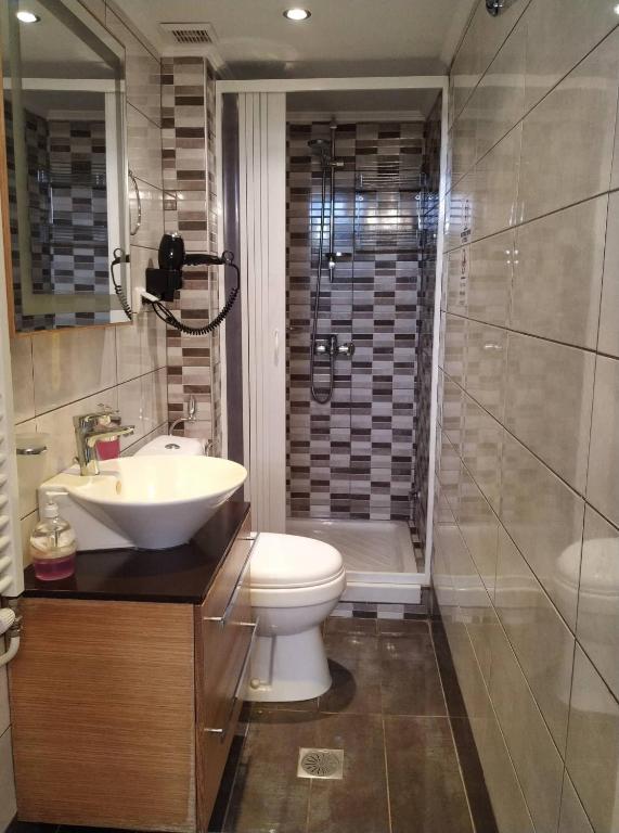 łazienka z toaletą, umywalką i prysznicem w obiekcie Palm Garden Villa w mieście Orfánion