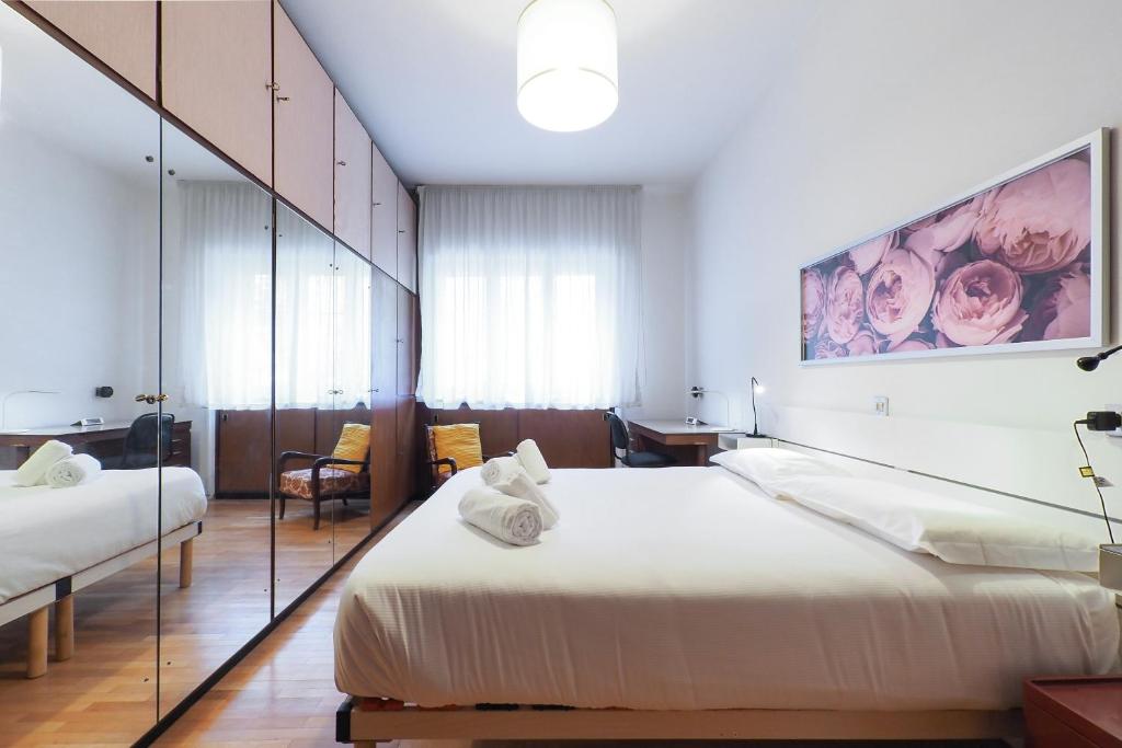 um quarto de hotel com duas camas e um espelho em PrimoPiano - Tolmezzo em Milão