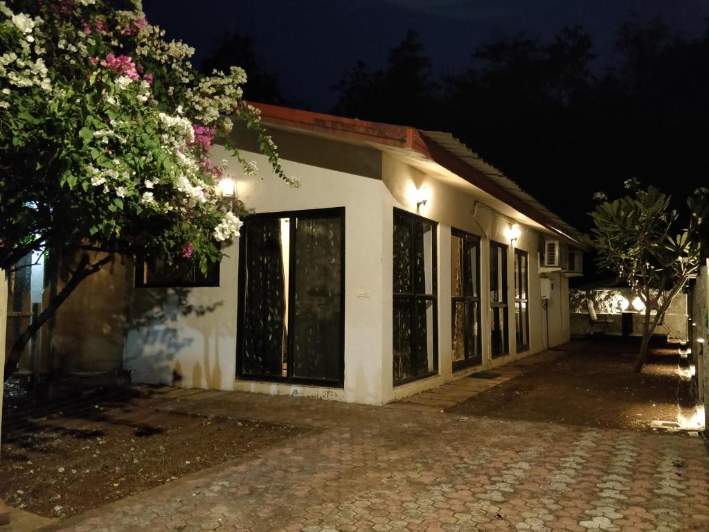 a white building with windows at night at Chalet Casa Amor, Perfect home amidst tranquility in Karjat