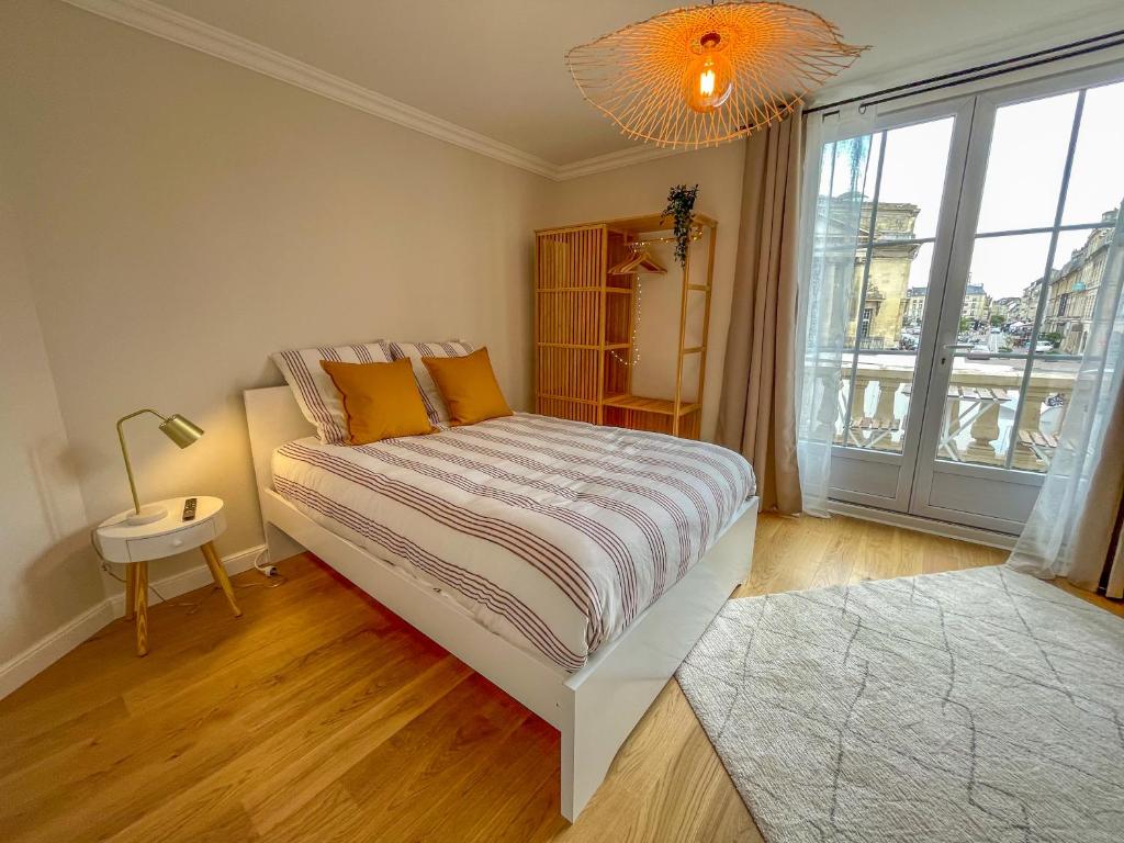 a bedroom with a bed and a large window at Studio rénové avec terrasse et vue unique ! in Caen