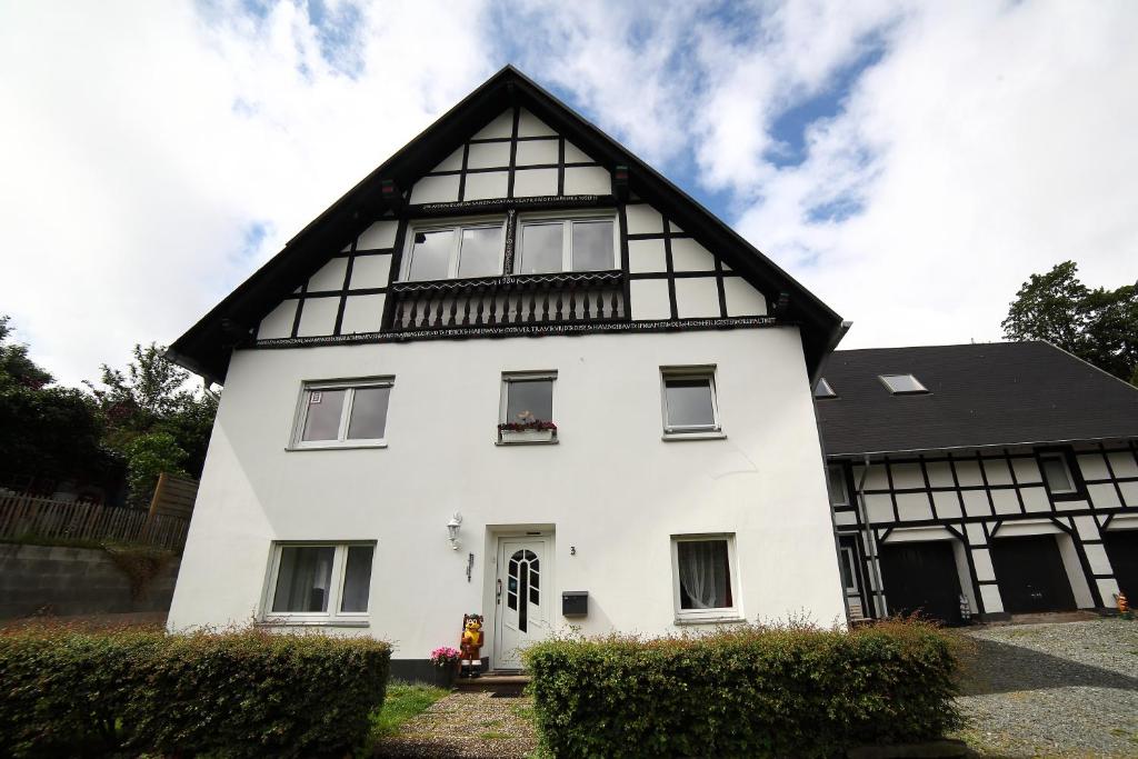 a white house with a black roof at Landhaus Silbach in Winterberg