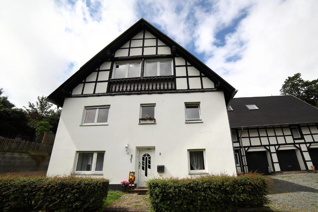 una casa blanca con techo negro en Landhaus Silbach, en Winterberg