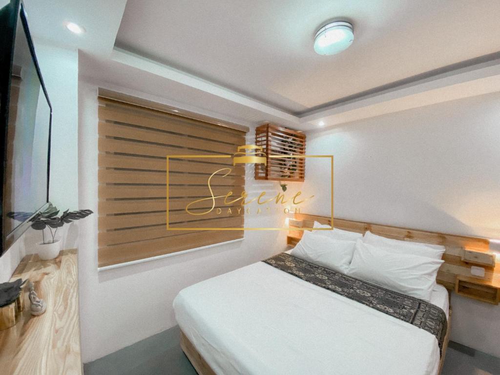 ein Schlafzimmer mit einem Bett mit einem Schild an der Wand in der Unterkunft Serene Daycation Antipolo in Cupang
