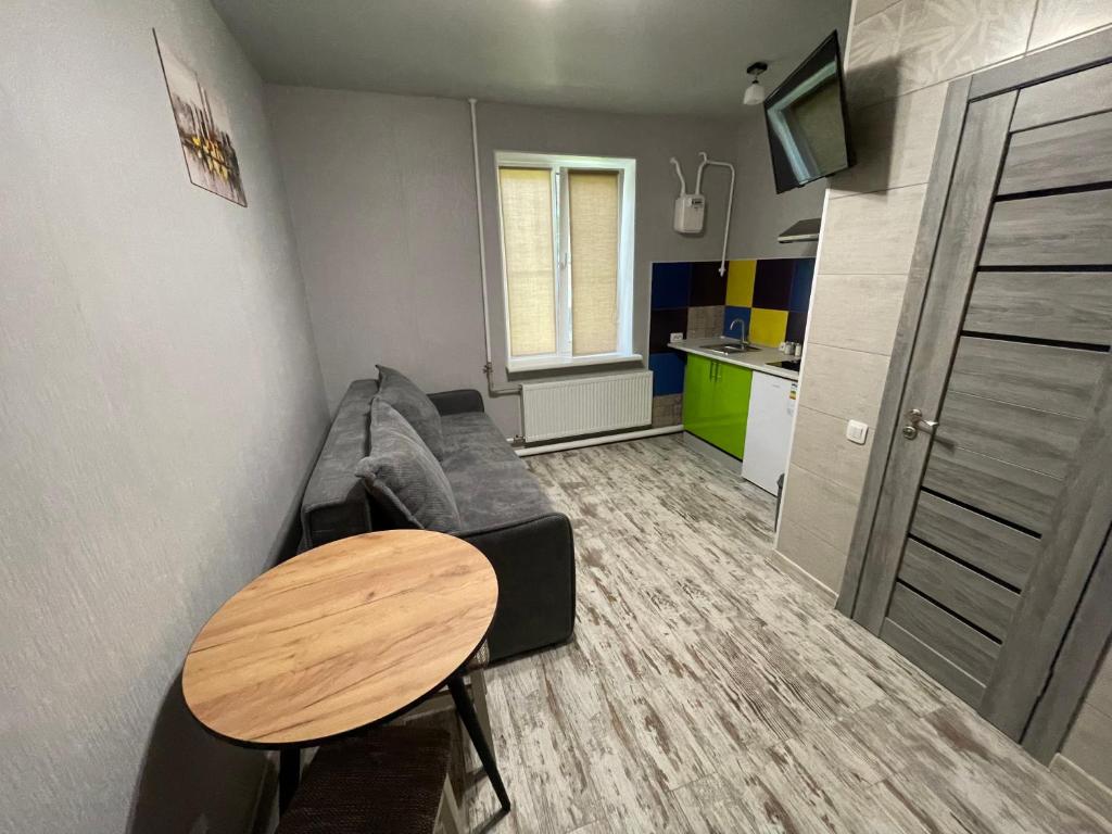 sala de estar con sofá y mesa en Смарт-квартира біля озера en Vínnytsia