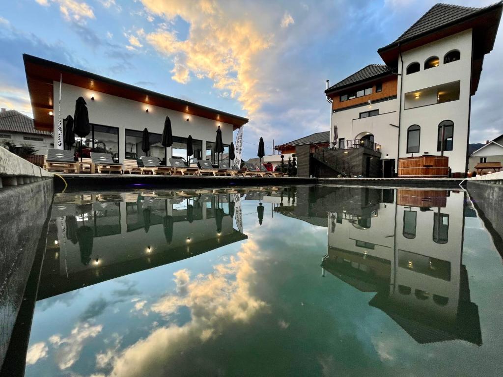 a pool of water in front of a building at Pensiunea Maramures Guesthouse in Vişeu de Jos