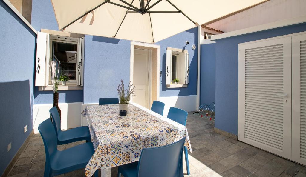 uma mesa e cadeiras com um guarda-sol num pátio em Casa Boscolo Family - Luxury House em Chioggia