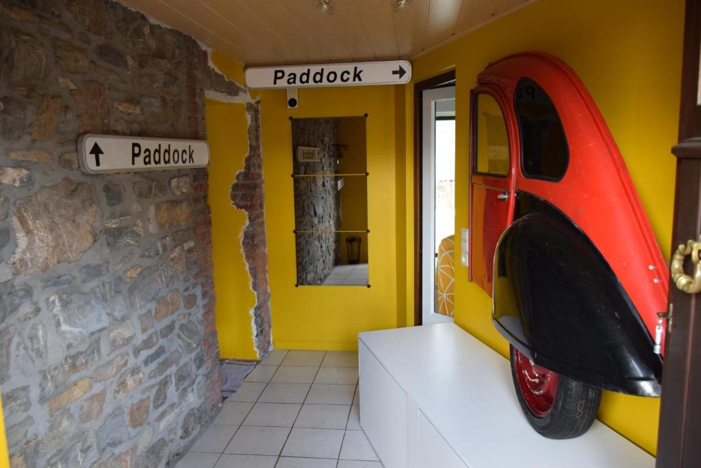 une chambre avec une voiture rouge garée dans un garage dans l'établissement Piece of Race, à Francorchamps