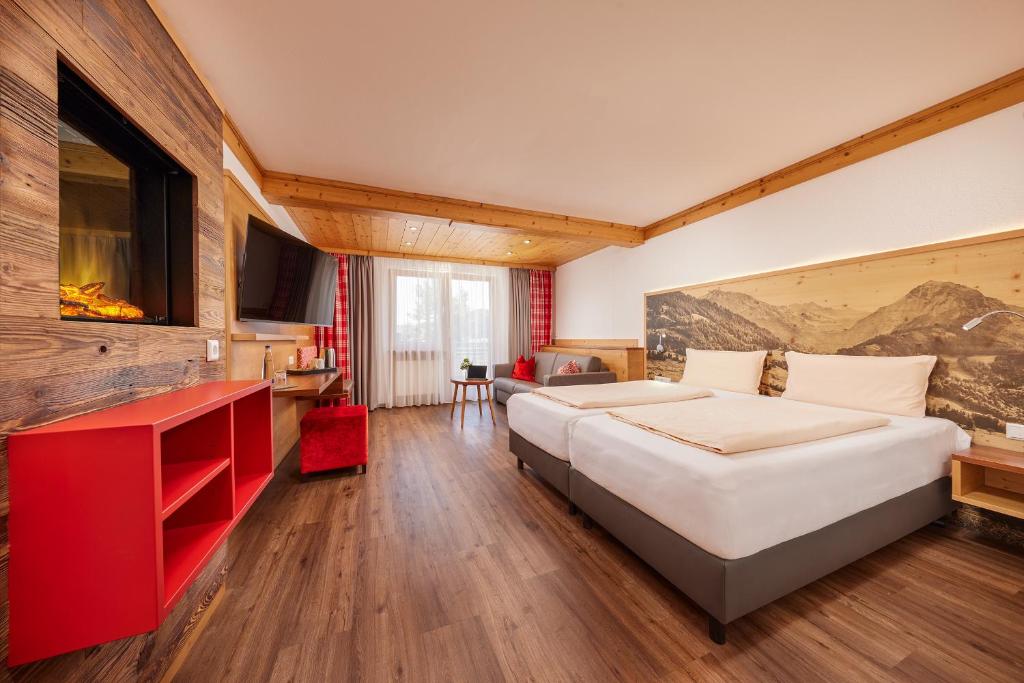 ein Hotelzimmer mit 2 Betten und einem TV in der Unterkunft Hotel Am Kamin in Kaufbeuren