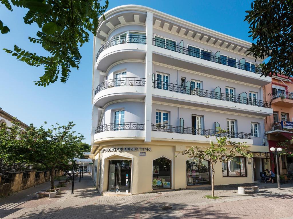 un edificio blanco alto con balcones en una calle en Hotel Hermes en Rodas