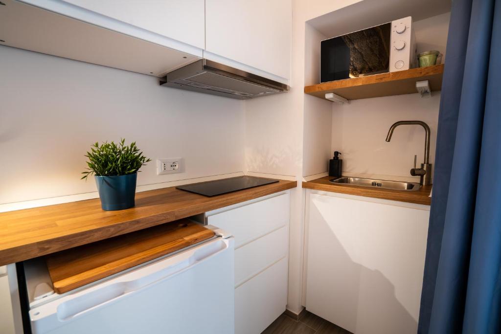 a small kitchen with white cabinets and a sink at Vico Blu in Polignano a Mare
