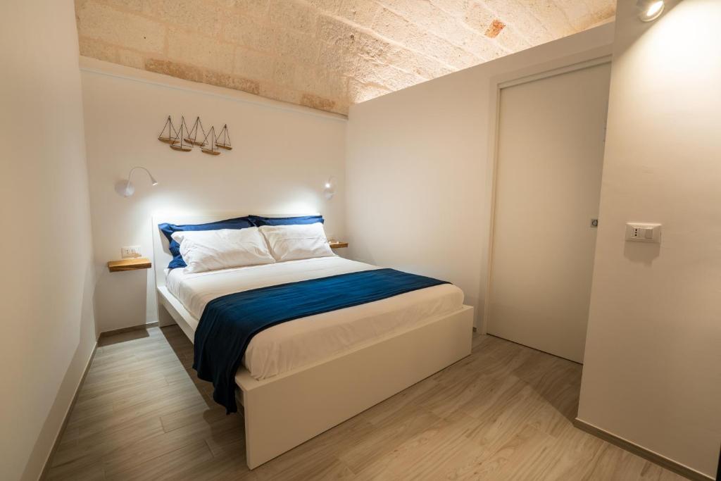 a bedroom with a bed with blue and white sheets at Vico Blu in Polignano a Mare