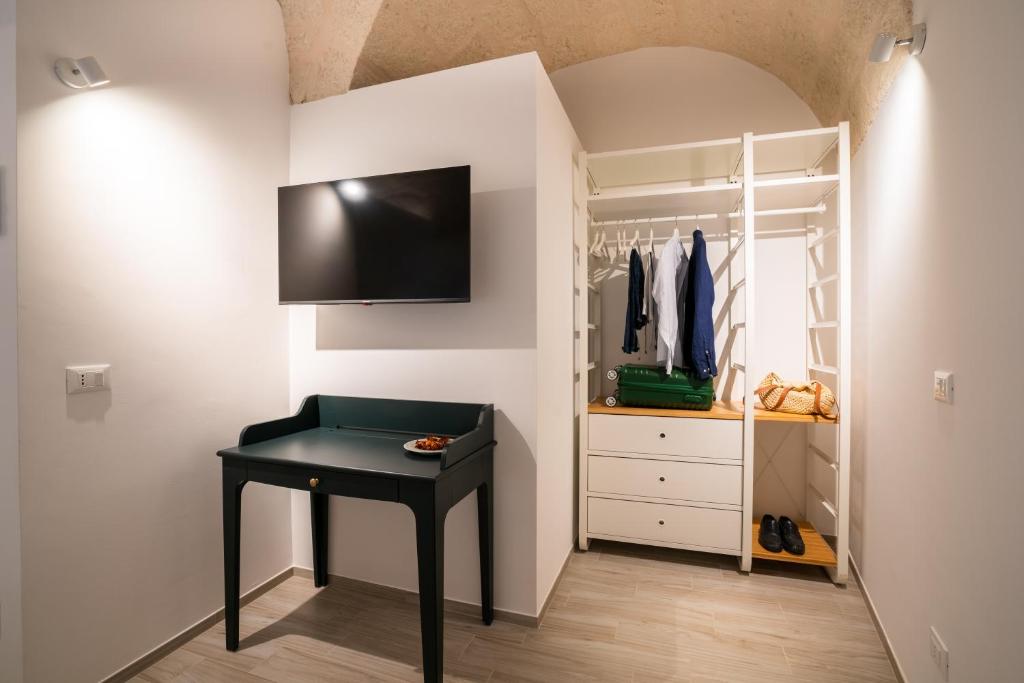 a room with a black desk and a closet at Vico Blu in Polignano a Mare