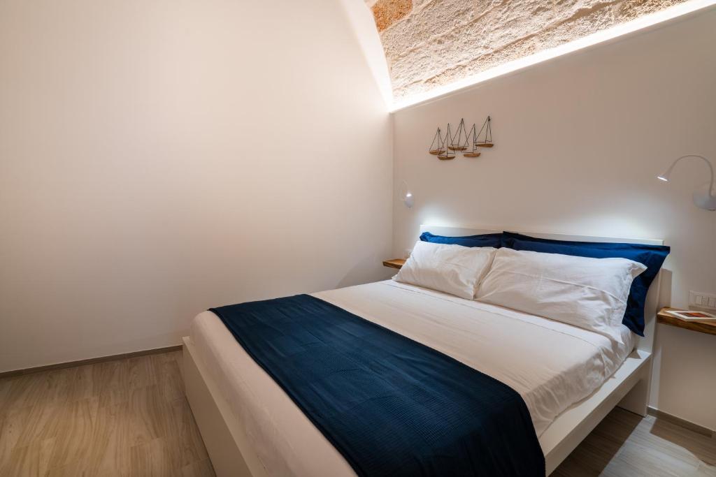 a bedroom with a bed with blue and white sheets at Vico Blu in Polignano a Mare