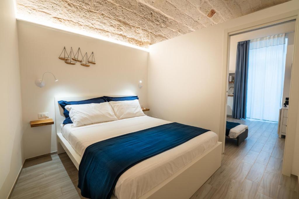 a bedroom with a large bed with blue sheets at Vico Blu in Polignano a Mare