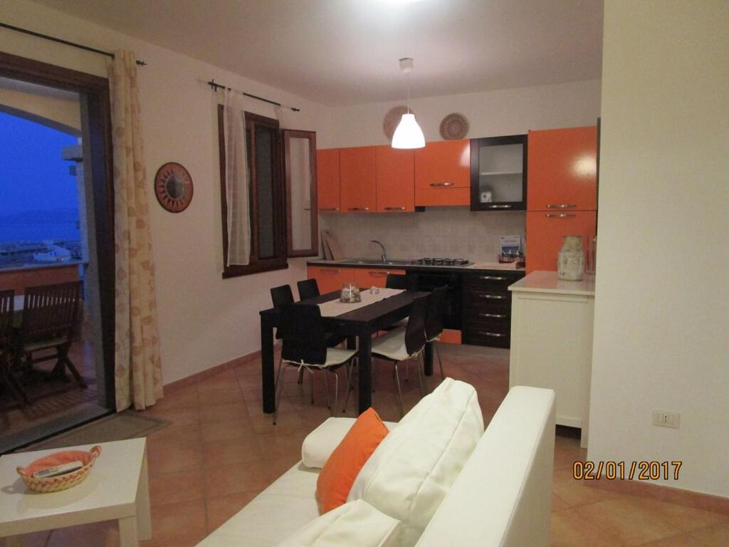 een woonkamer en een keuken met een tafel en een bank bij Appartamento con vista meravigliosa in Castelsardo