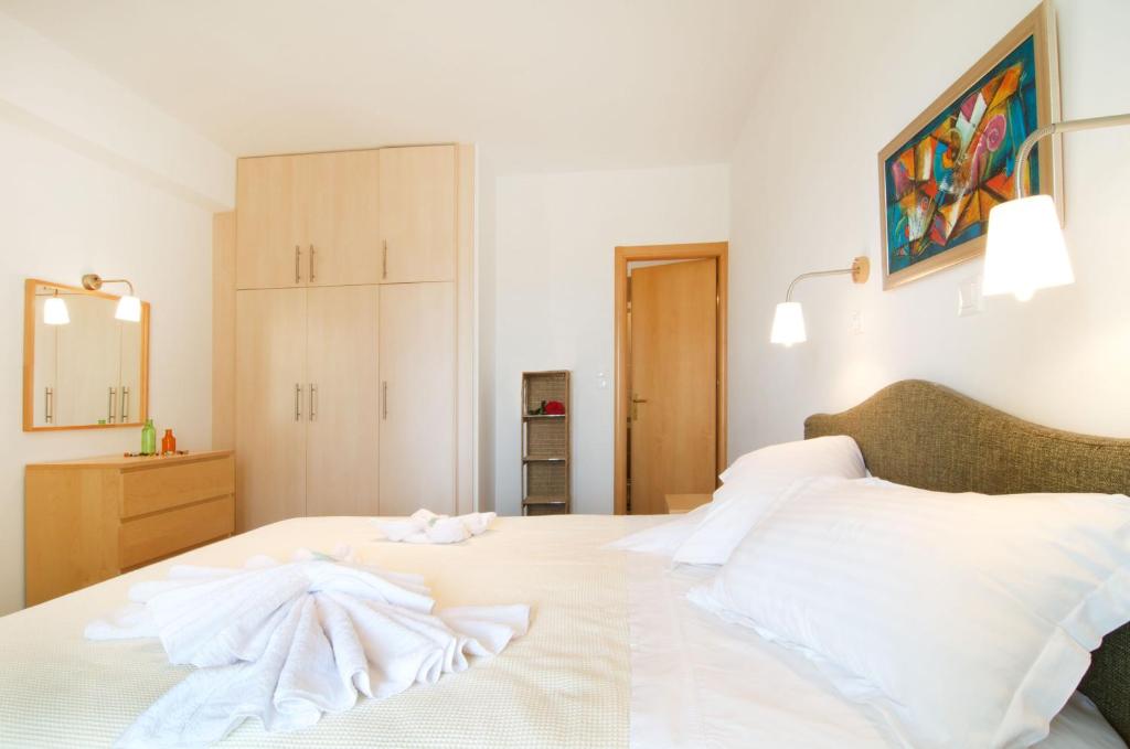 a bedroom with a white bed with white sheets at Miraluna Aparthotel in Lefkos Karpathou