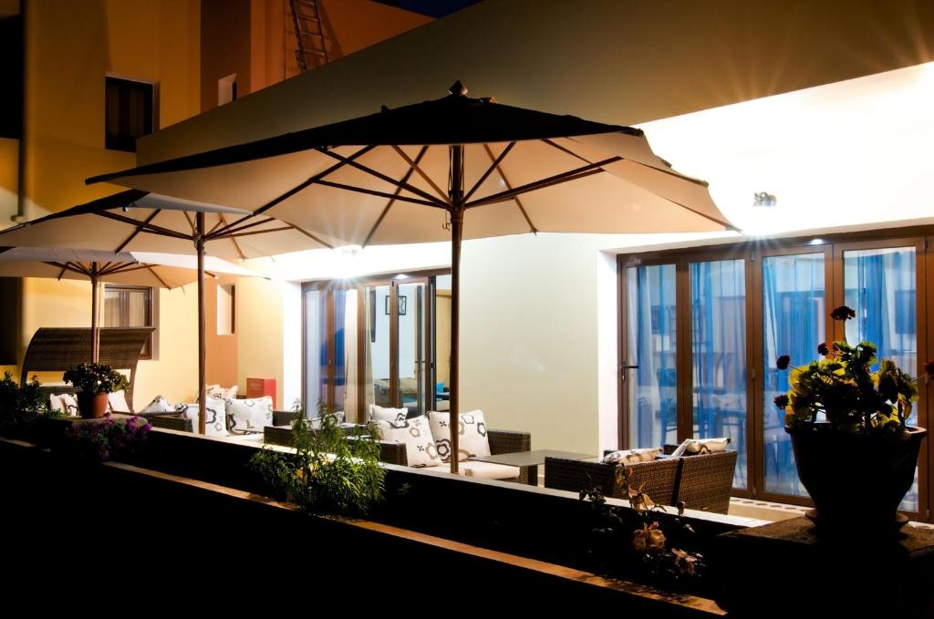 two umbrellas in a room with chairs and tables at Miraluna Aparthotel in Lefkos Karpathou