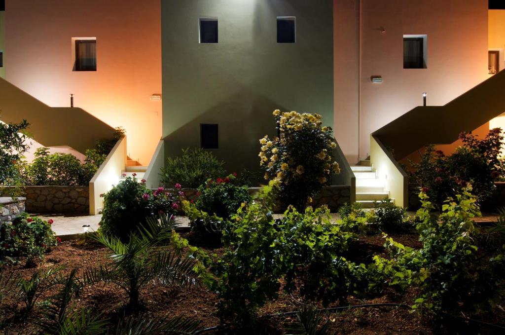 a garden in front of a building with flowers at Miraluna Aparthotel in Lefkos Karpathou