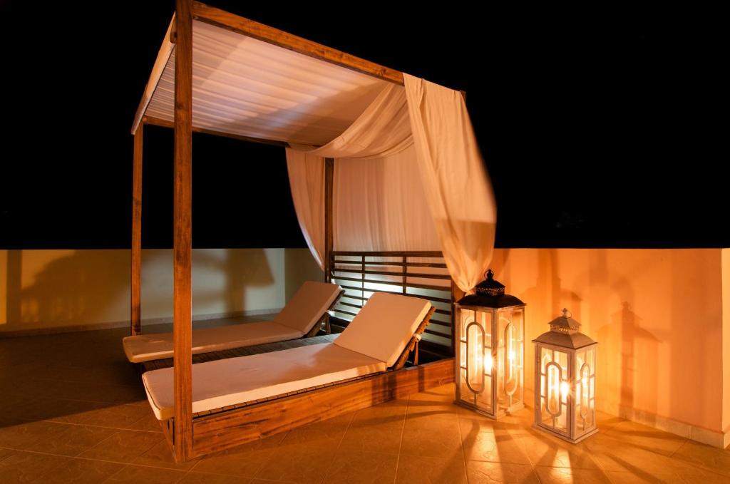 a porch with a bed and a lamp and a lantern at Miraluna Aparthotel in Lefkos Karpathou