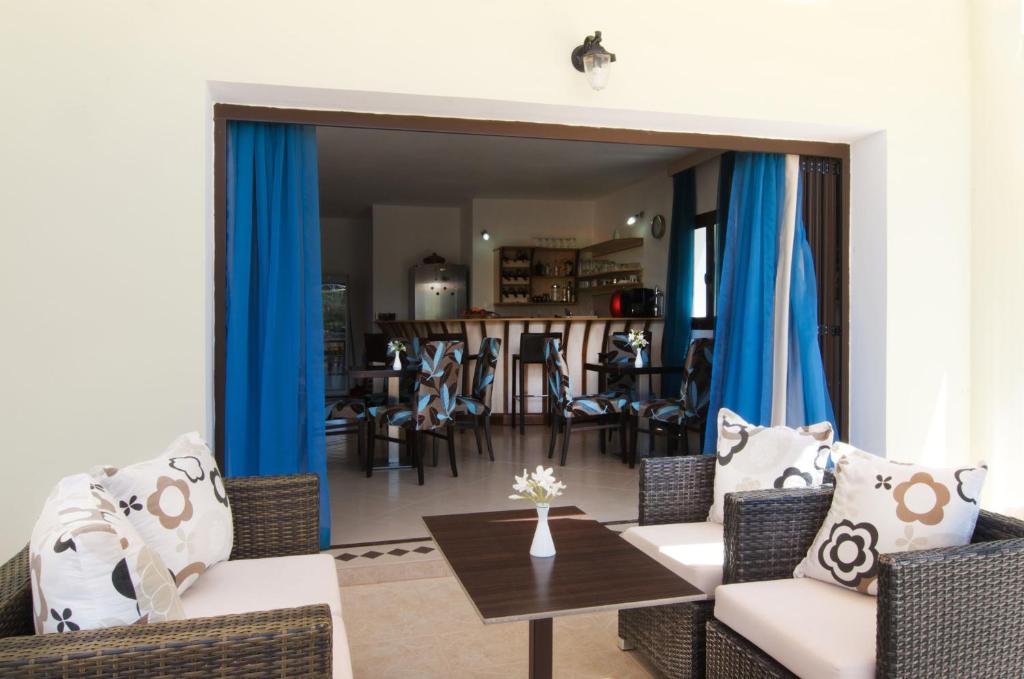 a living room with chairs and a table and a mirror at Miraluna Aparthotel in Lefkos Karpathou
