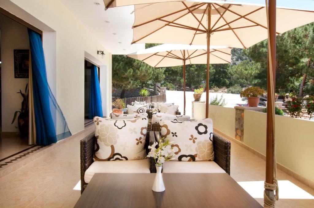 a dining room with a table and umbrella at Miraluna Aparthotel in Lefkos Karpathou
