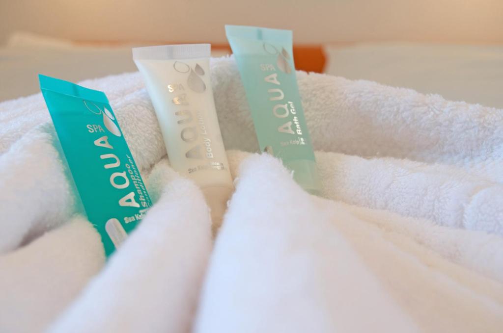 a pile of white towels sitting on a bed at Miraluna Aparthotel in Lefkos Karpathou