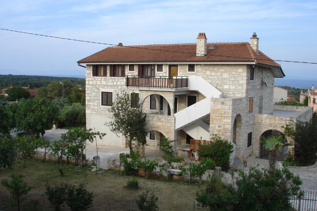 een groot stenen huis met een balkon. bij Kamena kuca Smiljevac - Stone house Apartment 2 in Ližnjan