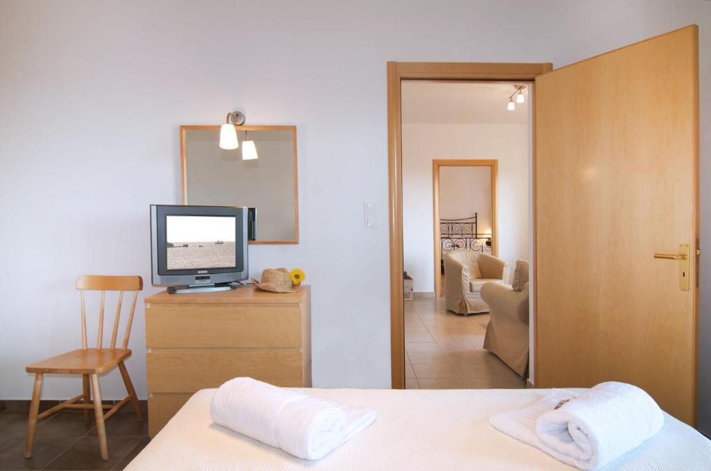 a bedroom with a bed and a television in a room at Miraluna Aparthotel in Lefkos Karpathou