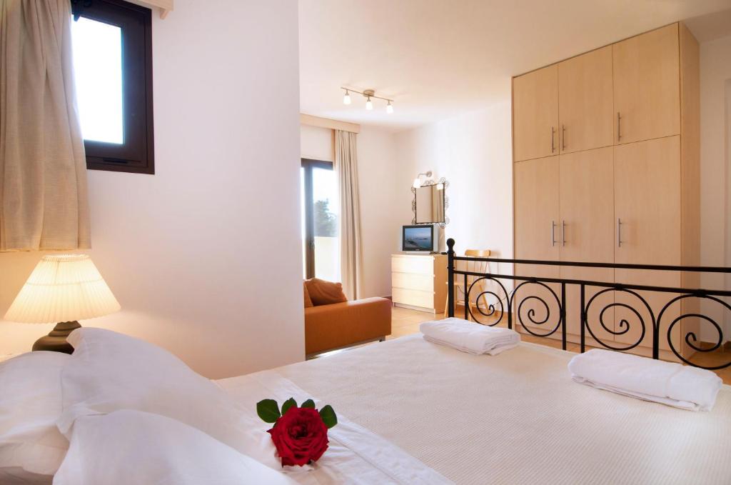a bedroom with a bed with a red stuffed animal on it at Miraluna Aparthotel in Lefkos Karpathou