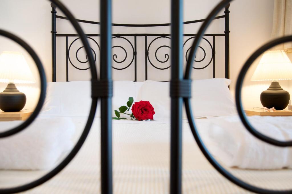 a red rose on a bed with white pillows at Miraluna Aparthotel in Lefkos Karpathou