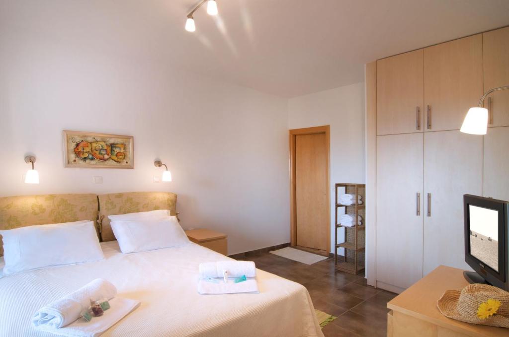 a bedroom with a bed and a tv in it at Miraluna Aparthotel in Lefkos Karpathou