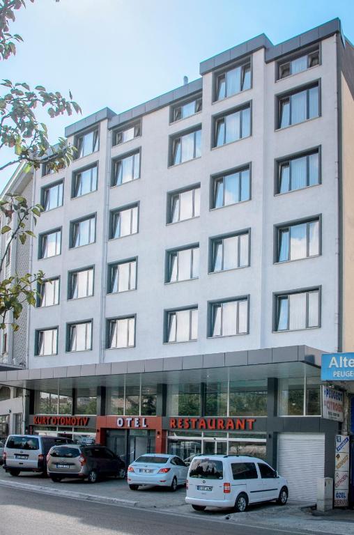 a large white building with cars parked in front of it at KURT OTEL in Degirmen