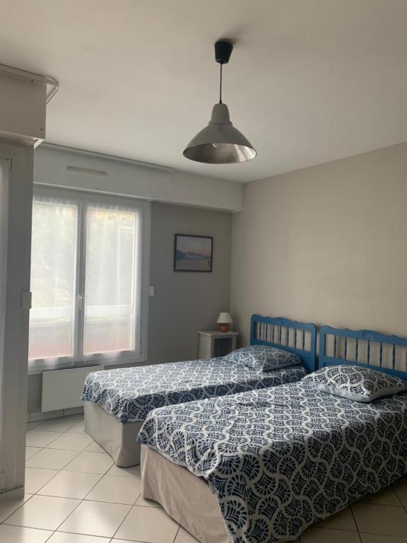 une chambre avec deux lits et une fenêtre dans l'établissement 7 Boulevard des Côtes, à Aix-les-Bains