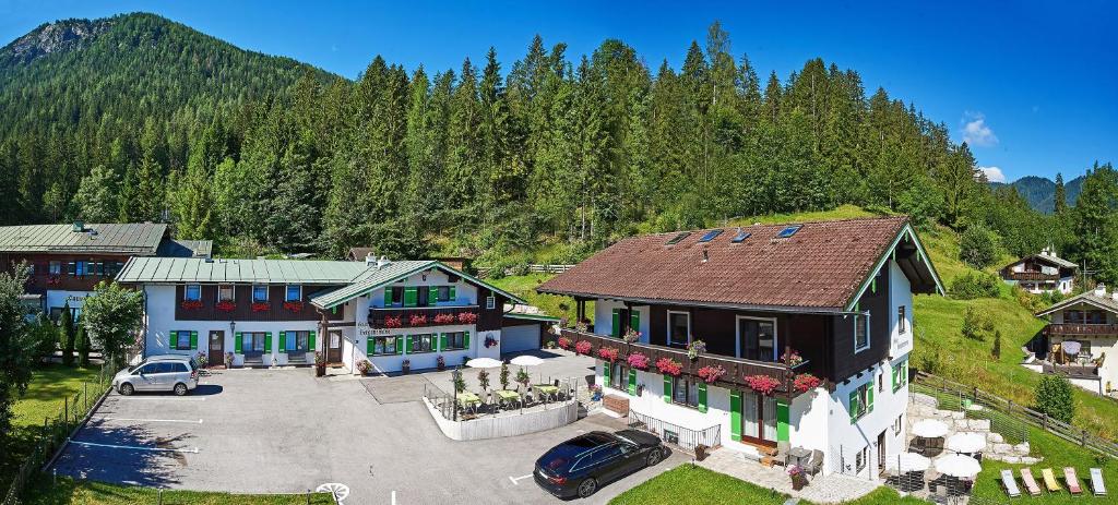 eine Luftansicht eines Hauses mit Parkplatz in der Unterkunft Ferienwohnungen Berganemone in Schönau am Königssee