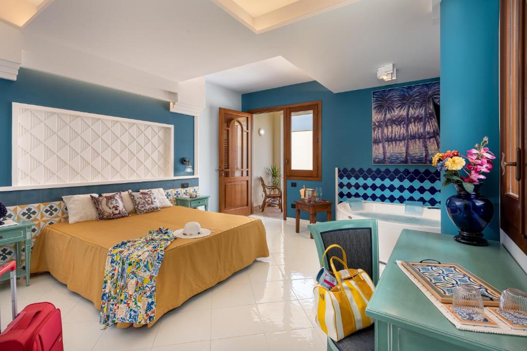 a bedroom with a bed and a bath room at Hotel Sicilya in San Vito lo Capo