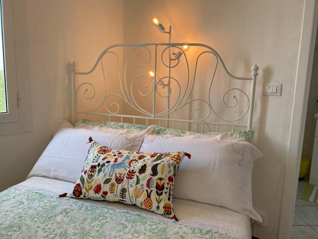 een bed met een metalen hoofdeinde met een kussen en verlichting bij “Da Senso” Relax nel verde vista mare in Finale Ligure