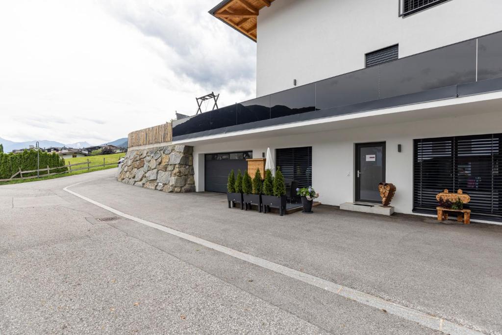 un gran edificio blanco con una pared de piedra en Apart Sabrina Fügen en Fügen