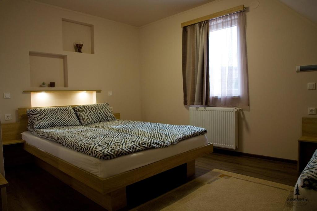 Schlafzimmer mit einem Bett und einem Fenster in der Unterkunft Casa de oaspeți Csomortáni vendégház in Şoimeni