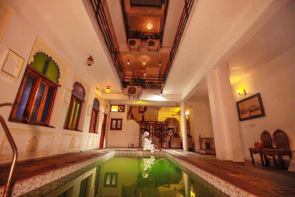 een vrouw in een zwembad in een huis bij Hotel Devraj Niwas on Lake Pichola in Udaipur